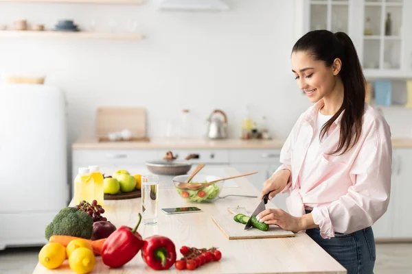 Retrato de una joven sonriente cocinando ensalada fresca — Foto de Stock