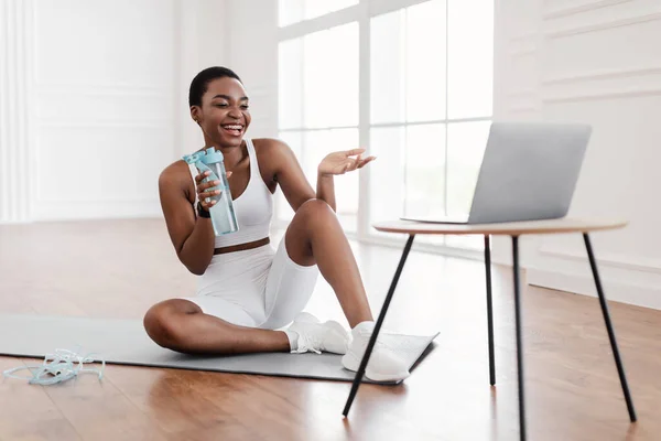 Mujer negra joven haciendo ejercicio con entrenador en línea usando PC — Foto de Stock