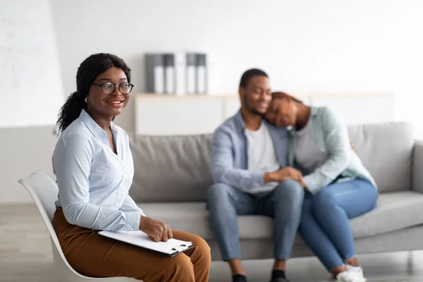 Vrolijke vrouwelijke psycholoog en jong zwart paar knuffelen na effectieve therapie op kantoor, kopiëren ruimte — Stockfoto