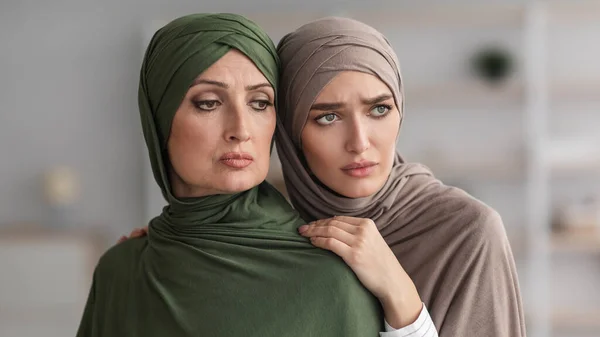 Wanita muslim senior yang tidak bahagia dan putrinya yang dewasa merangkul dalam ruangan — Stok Foto