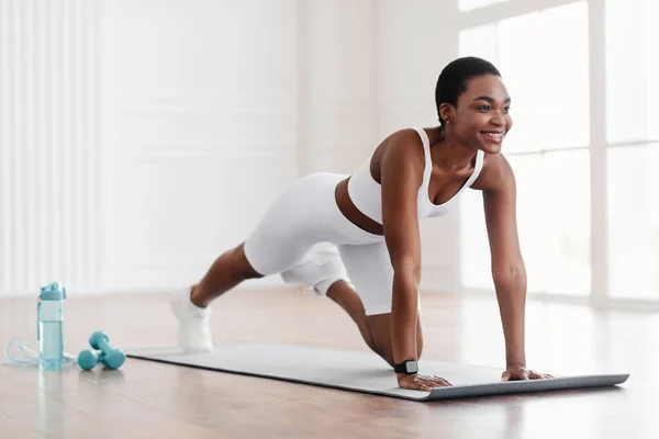 Afro fröhliche Frau macht Cross Body Bergsteiger-Übung — Stockfoto