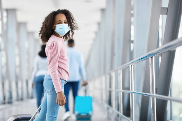 Chica negra feliz mirando hacia atrás, de pie en el aeropuerto —  Fotos de Stock