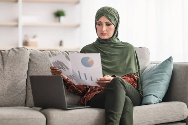 İç mekanda çalışan İstatistiklere bakarak Laptop kullanan Müslüman İş Kadını — Stok fotoğraf