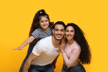 Aile zamanı. Mutlu Arap anne ve babasının ve kızının birlikte eğlendiğinin portresi