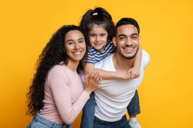 Aile Teklifi. Sarı Arkaplan Üzerinde Küçük Kızlı Mutlu Arap Ebeveynlerin Portresi