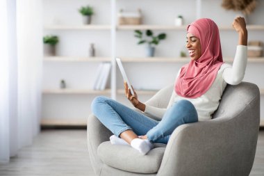 Sayısal Tablet 'e bakıp Neşeyle Övünen Heyecanlı Zenci Müslüman Kadın