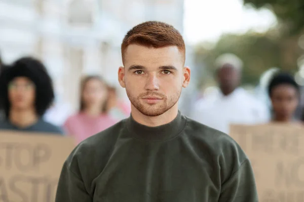 Sérieux jeune homme debout sur la foule avec des pancartes — Photo