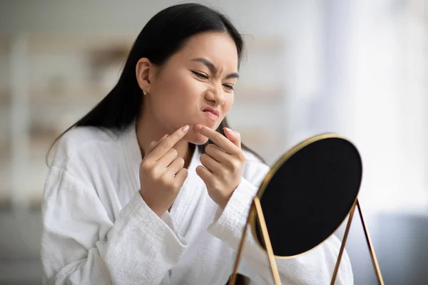 Young asian lady in bathrobe removing black heads — Stock Photo, Image