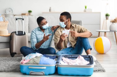 Siyah Çift Akıllı Telefon Paket Çantası Kullanıyor, Kapalı Kapılar ardında, Yüz Maskeleri Giyiyorlar