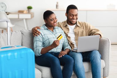 Siyah Çift Evdeki Dizüstü bilgisayarını kullanarak İnternet 'ten bilet alıyor.