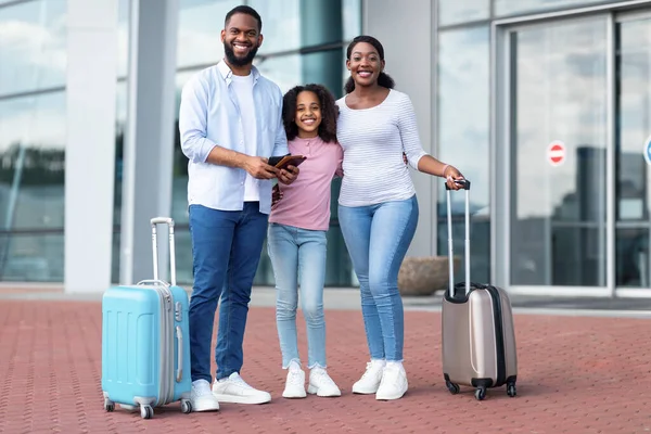 Feliz família negra viajando, segurando documentos perto do aeroporto — Fotografia de Stock