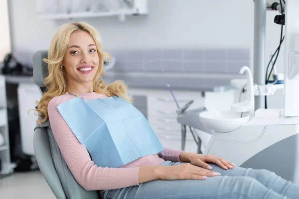 Mujer joven rubia paciente sonriendo en odontología, espacio para copiar — Foto de Stock