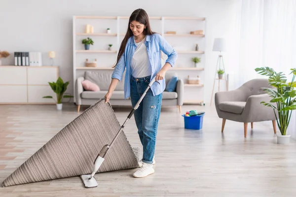 Portrét ženy úklid podlahy v obývacím pokoji pomocí mop — Stock fotografie