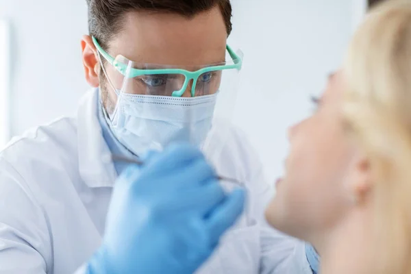 Primer plano del hombre dentista haciendo tratamiento para el paciente femenino —  Fotos de Stock