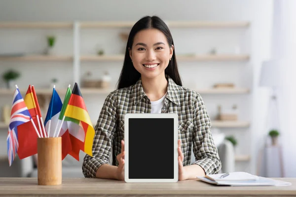 Happy asian woman showing digital tablet with blank screen — Stock Photo, Image