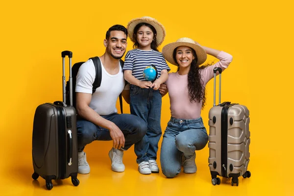 Des vacances. Heureuse famille arabe de trois avec des valises posant sur fond jaune — Photo