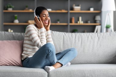 Yurtiçi Hobi. Neşeli Afrikalı Kadın Evde Kablosuz Kulaklıkla Müzik Dinliyor