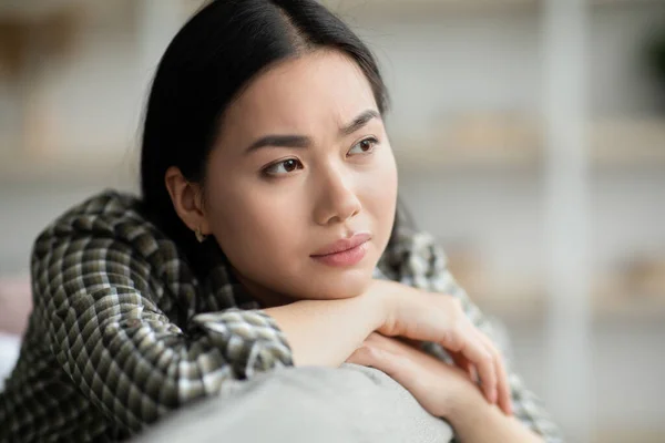 Close-up van boos jonge vrouw zitten op de bank en huilen — Stockfoto