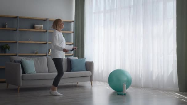 Mujer mayor haciendo ejercicio con cuerda de salto en casa, longitud completa — Vídeos de Stock