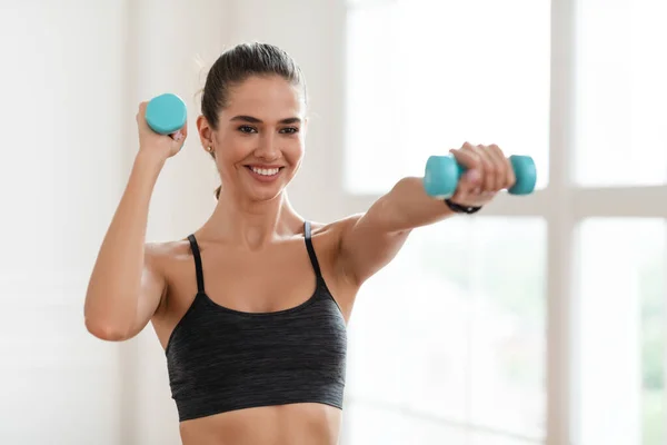 Lycklig sportig kvinna tränar med två hantlar och Posing — Stockfoto