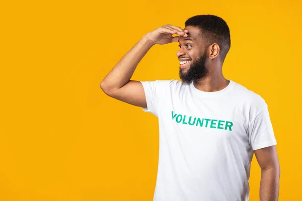 Afrikanischer Freiwilliger Guy schaut auf Kopierraum, gelber Hintergrund — Stockfoto