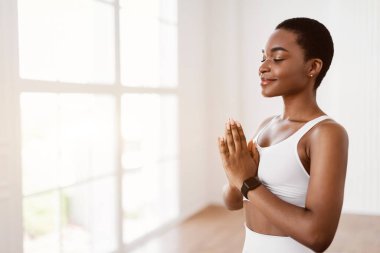 Siyahi kadın dua ederken el ele tutuşarak meditasyon yapıyor.