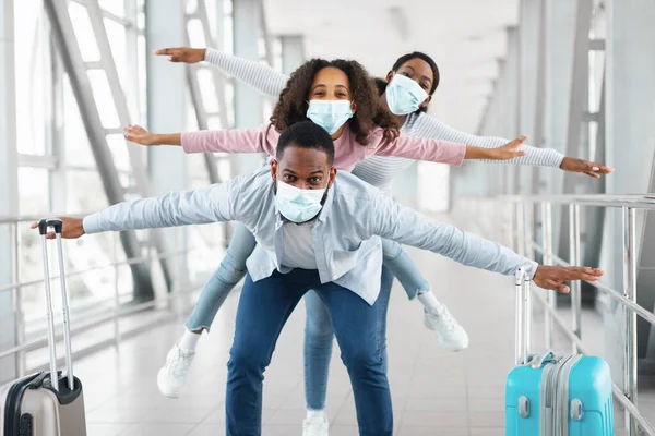 Feliz familia negra viajando con su hija, divirtiéndose en el aeropuerto —  Fotos de Stock