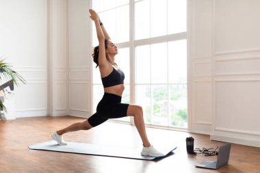 Genç bir kadın dizüstü bilgisayarın önüne atlıyor.