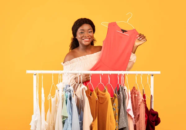 Compras e moda de verão. Mulher negra tomando cabide com vestido elegante de prateleira de roupas, escolhendo novo olhar da moda — Fotografia de Stock