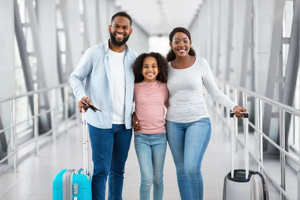 Happy black family traveling, holding documents in airport — Stock Photo, Image