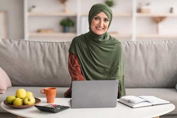 Happy Mature Islamic Lady Menggunakan Laptop Smiling Sitting At Home — Stok Foto