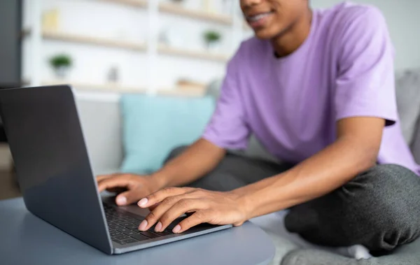 Η έννοια της ηλεκτρονικής μάθησης. Αφροαμερικανός έφηβος που σπουδάζει online, πληκτρολογεί σε φορητό υπολογιστή στο σπίτι, κοντινό πλάνο των χεριών — Φωτογραφία Αρχείου