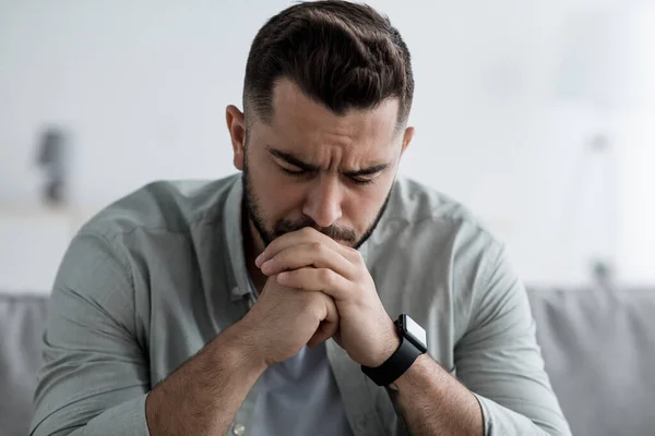 L'uomo si siede sul divano e si sente stressato a cattive notizie, depressione, solitudine — Foto Stock