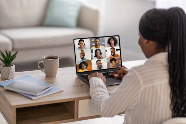 Black woman having online conference with colleagues while working at home office — Stock Photo, Image