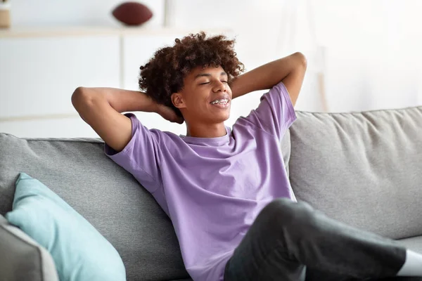 在寒冷的检疫期间，快乐的黑人青少年在舒适的沙发上休息 — 图库照片