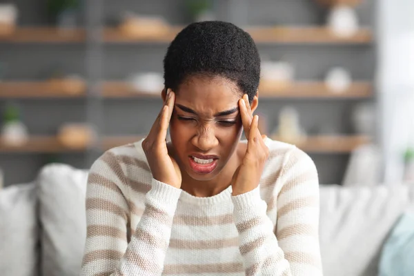 Junge Afroamerikanerin leidet zu Hause unter Kopfschmerzen oder Migräne — Stockfoto