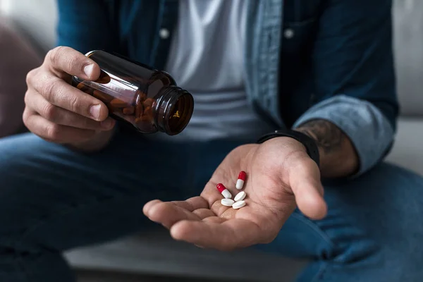 Un puñado de pastillas blancas en la palma de los pacientes masculinos. Atención médica, tratamiento, medicamentos y depresión, dolor y suicidio — Foto de Stock