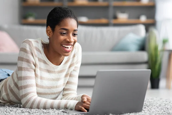 Alegre señora afroamericana relajante con computadora portátil en casa —  Fotos de Stock