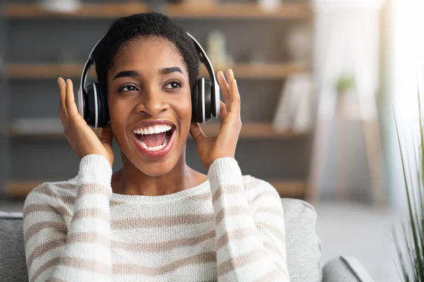 Ulubiony wypoczynek. Overjoyed African Woman W słuchawkach bezprzewodowych Słuchanie muzyki w domu — Zdjęcie stockowe
