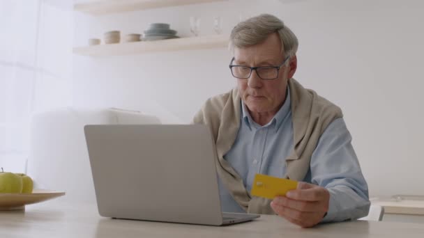 Conforto de pagamentos online. Homem sênior com cartão de crédito e laptop fazendo transação na internet, inserindo dados pessoais — Vídeo de Stock