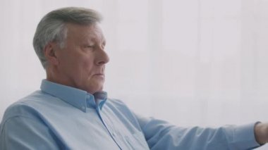 Yaşlanma ve görme sorunları. Gözlüklerini çıkarıp burun köprüsünü ovalayan yorgun yaşlı adamın portresi.