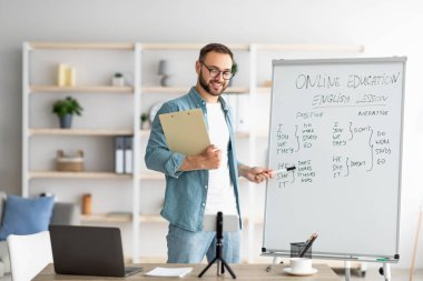 Uzaktan öğrenme ve çevrimiçi öğretim. Uzaktan İngilizce dersi veren kendinden emin erkek öğretmen, dilbilgisi pişmanlıklarını anlatıyor.