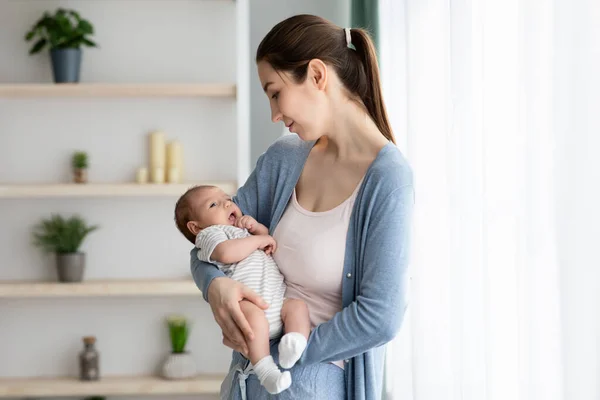 Bycie matką. Młoda piękna mama trzyma swoje nowo narodzone dziecko w ramionach — Zdjęcie stockowe