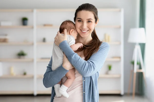 Boldog szülési időt! A gyönyörű, fiatal anya portréja, amint átöleli újszülött gyermekét — Stock Fotó