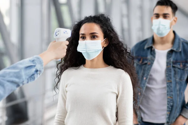 안 전한 여행. 직원들 이 공항 출입시 전자 온도계로 온도를 측정하는 모습 — 스톡 사진