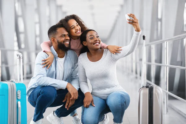 Familia negra viajando, tomando selfie en el teléfono celular en el aeropuerto — Foto de Stock