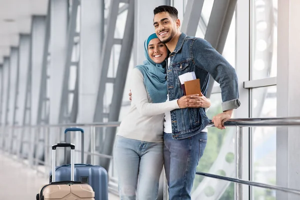 Felici sposi musulmani amorevoli che si abbracciano al terminal dell'aeroporto in attesa del volo — Foto Stock
