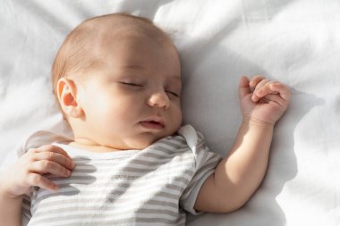 Gündüz uykusu zamanı. Yakından çekilen Sevimli Bebek Yatakta Uyuyor