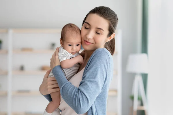 Concepto de maternidad. feliz joven amando mamá abrazando su lindo recién nacido bebé —  Fotos de Stock