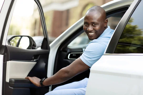 Pozitív afro-amerikai férfi beszáll a vadiúj autójába — Stock Fotó